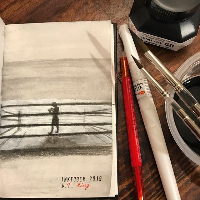 Grey and white ink drawing of the silhouette of a boxer in a ring. The open artbook is on a wooden table next to a red 'frixion' red ballpoint pen, a white ink brushphen, a bottle of black ink and two brushes resting on black water in a plastic cup.