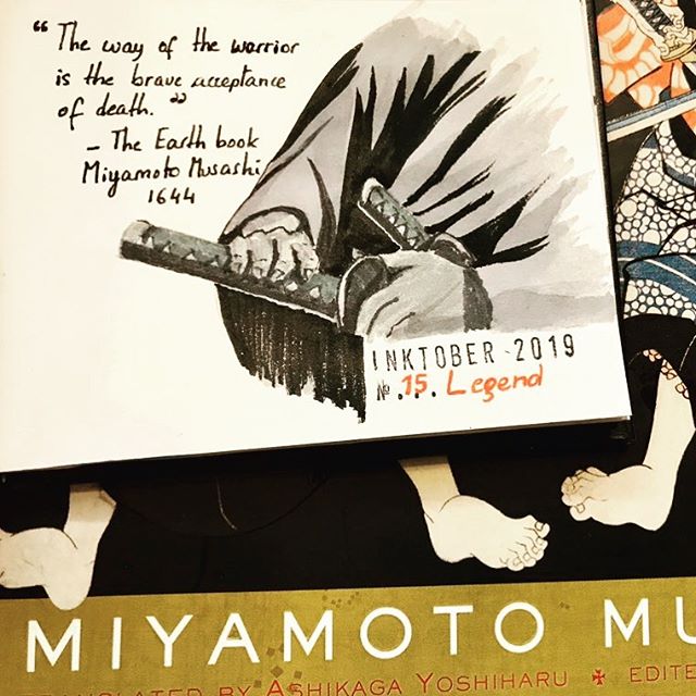 Black and grey ink drawing of hands on the handle of a Japanese sword. I wrote a quote by Miyamoto Musashi from the Earth book in 1644: 'The way of the warrior is the brave acceptance of death.' The open artbook is resting on top of the book on Miyamoto Mushashi: the book of the five rings.