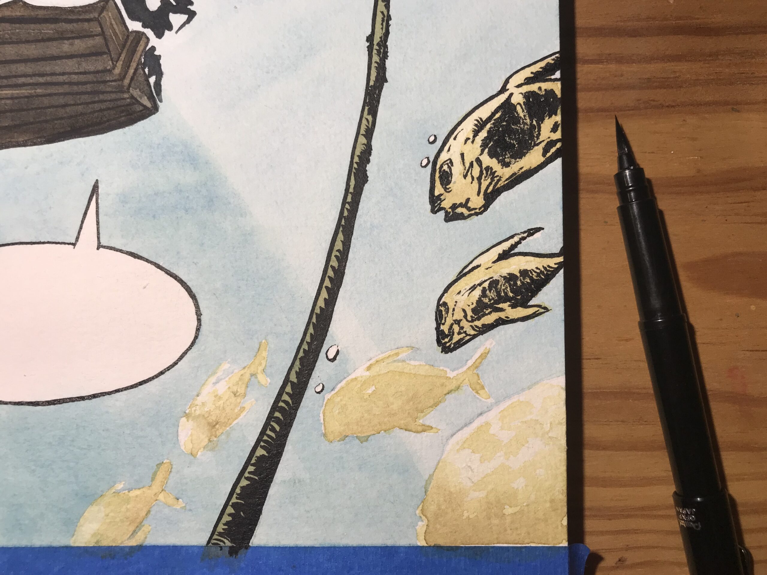 Detailing the fish using a Pentel black ink brushpen which is visible next to the sheet.