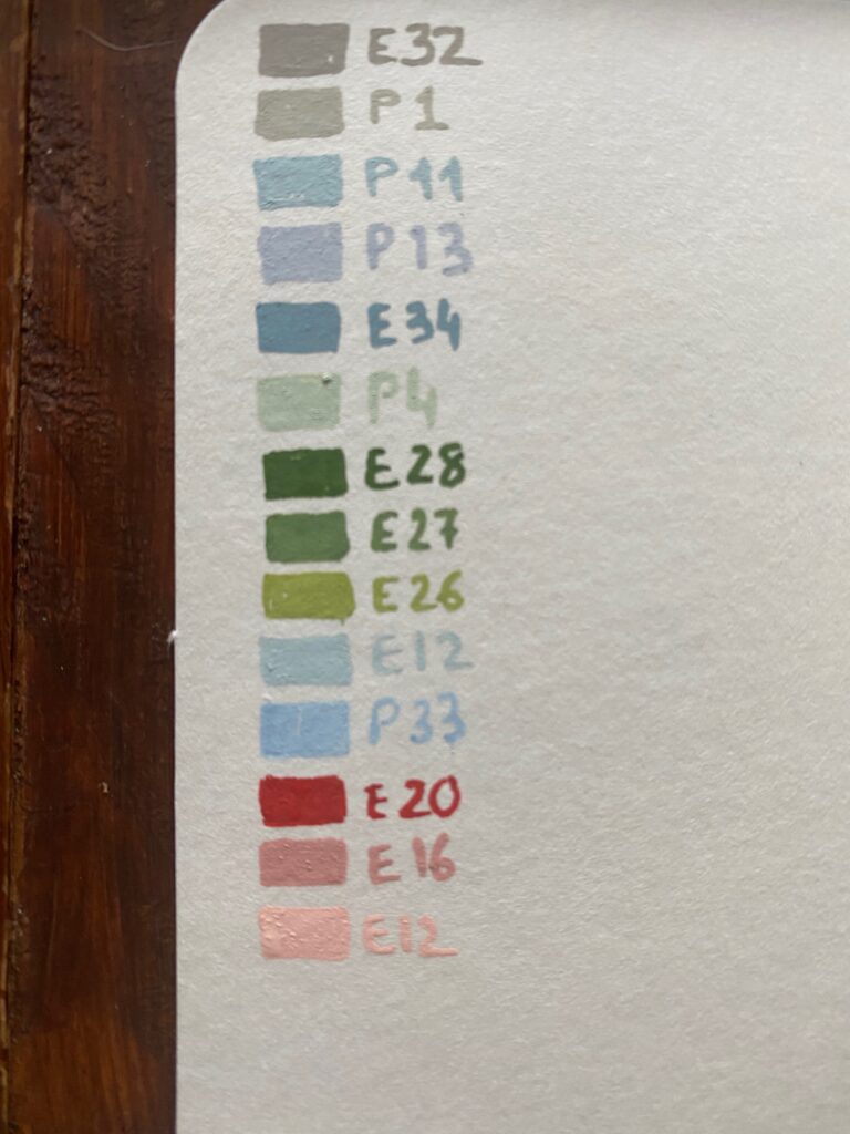 The back of the postcard where I painted small rectangles of the colours I used and their reference number.