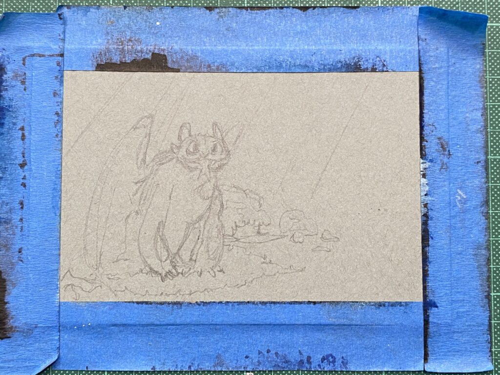 Grey toned paper taped with masking tape and the pencil sketch of a sitting dragon with a fish in his mouth
