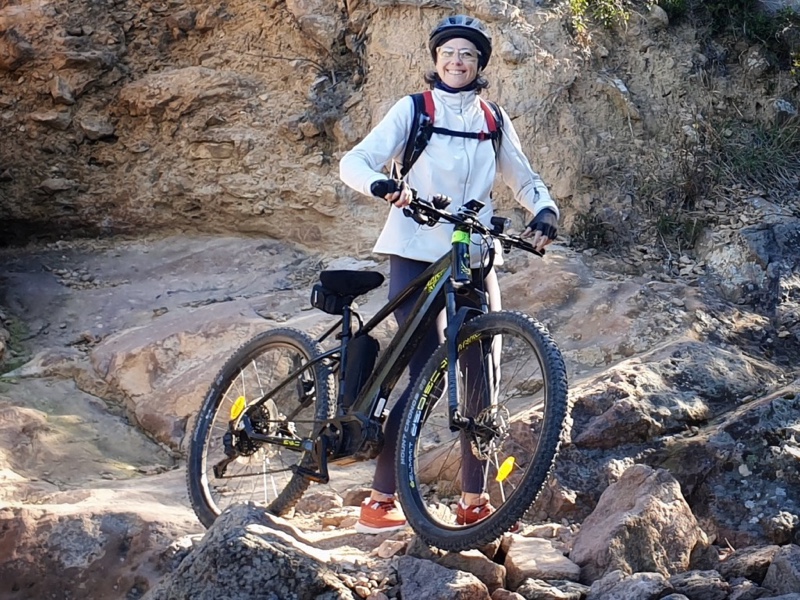 Photo of me smiling as a walk the electric mountain bike on fallen rocks