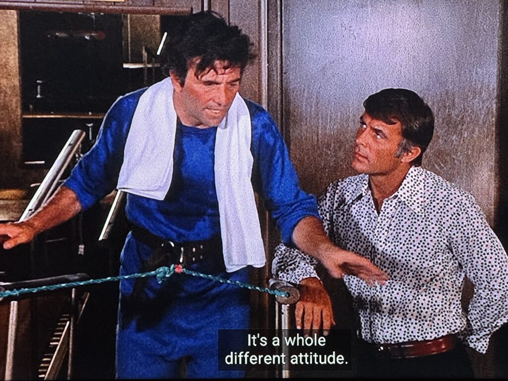 Lieutenant Columbo, harnessed to a treadmill, is sweating while in conversation with a character played by Robert Conrad. The caption reads “It’s a whole different attitude.”